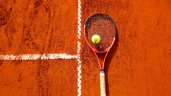 tennis ball on tennis racket on floor